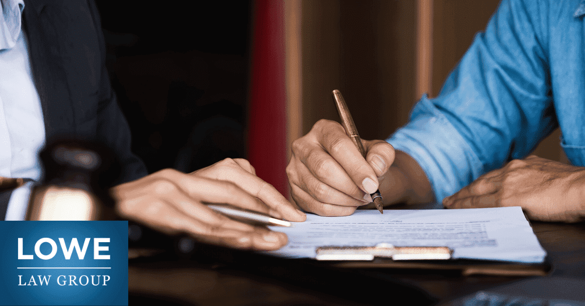 man signing settlement documents